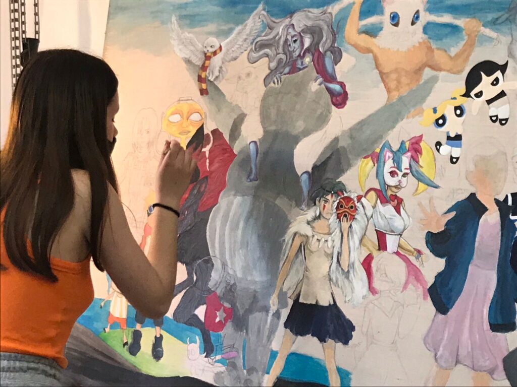 Alumna pintando mural solidario